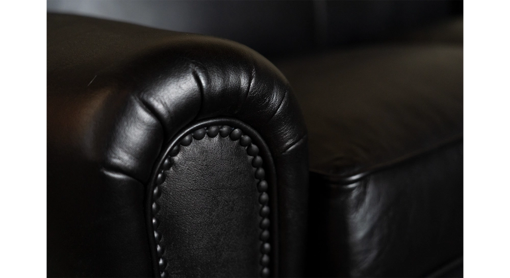 Canapé club cuir noir accoudoirs cloutés