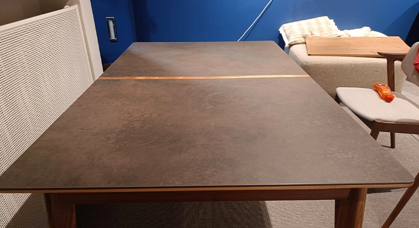 Table extensible 6 à 8 personnes en noyer et céramique allonges bois avec bois teinte naturelle et plateau céramique brun oxydé