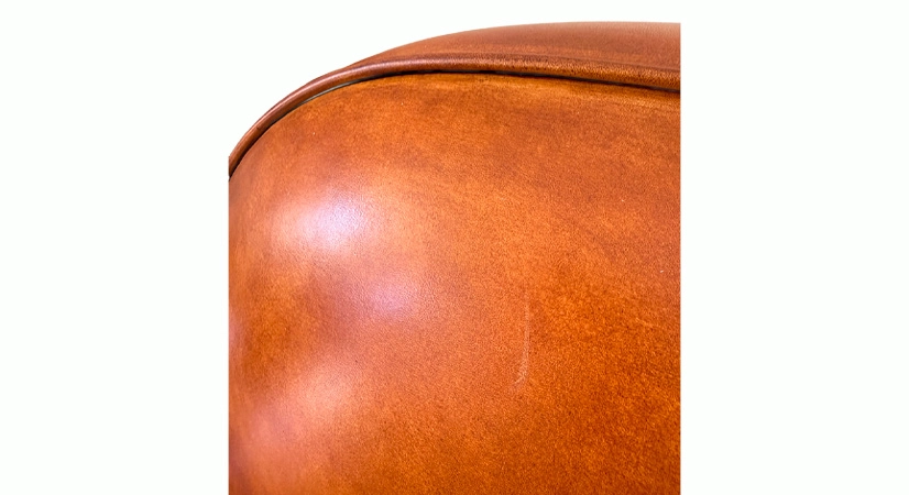Fauteuil club cuir marron clair accoudoirs cloutés