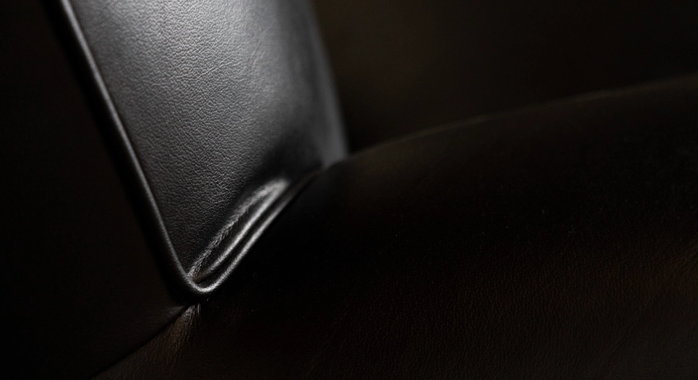 Canapé club cuir noir accoudoirs cloutés