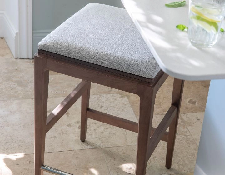 Tabouret de bar design H60 cm bois teinte noyer assise tissu beige naturel Tabouret de bar design H60 cm bois teinte noyer assise tissu beige naturel