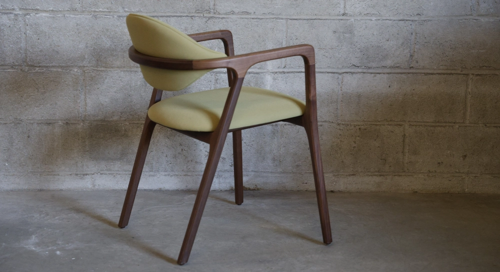 Chaise design avec accoudoirs en noyer bois teinte naturelle et tissu vert