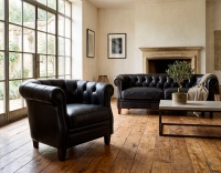 Fauteuil chesterfield cuir noir accoudoirs cloutés