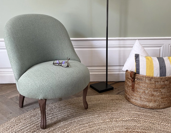 Armless toad chair walnut-stained wooden legs and sage green fabric