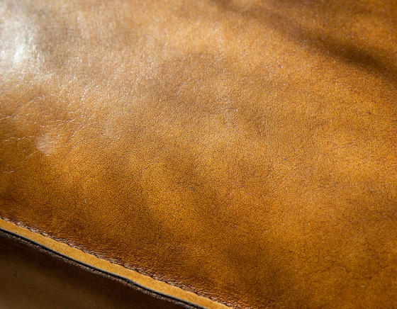 Fauteuil Chesterfield cuir cognac accoudoirs cloutés