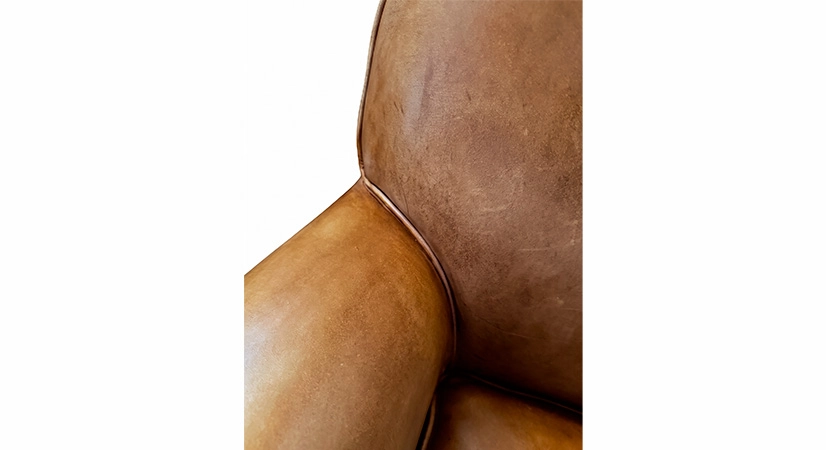 Fauteuil club cuir cognac accoudoirs cloutés