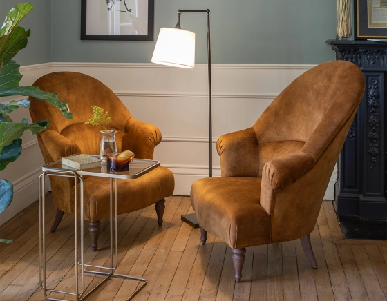 Fauteuil crapaud avec accoudoirs pieds bois teinte noyer et tissu velours bronze haut dossier