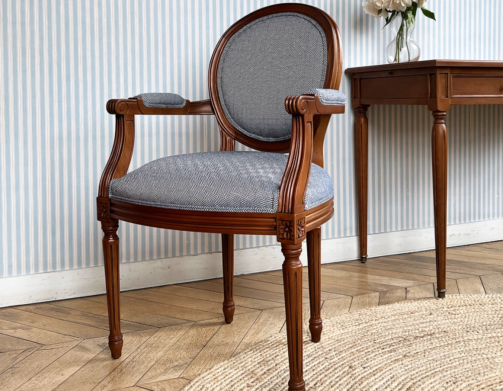 Antique Louis XVI style armchair with armrests aged wood stain and blue chevron fabric Antique Louis XVI style armchair with armrests aged wood stain and blue chevron fabric