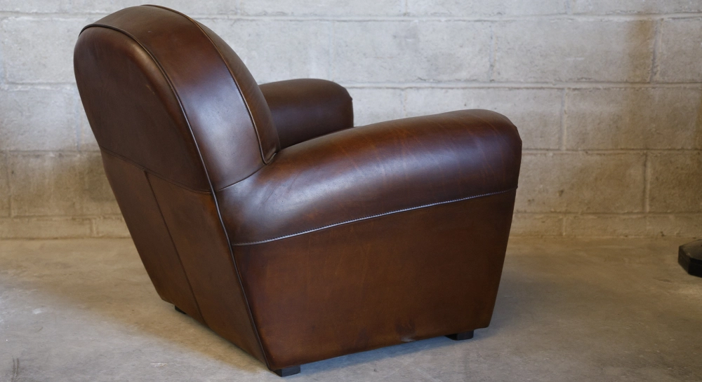 Fauteuil club cuir marron soutenu accoudoirs passepoil
