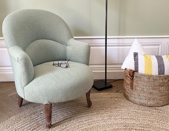 Fauteuil crapaud avec accoudoirs pieds bois teinte noyer et tissu vert sauge