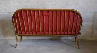 Scandinavian 2-seater sofa cherry wood stain and red fabric.