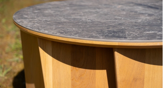 Round coffee table in oak and ceramic with natural wood finish and grey marble-effect ceramic top.