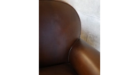 Fauteuil club cuir marron soutenu accoudoirs passepoil
