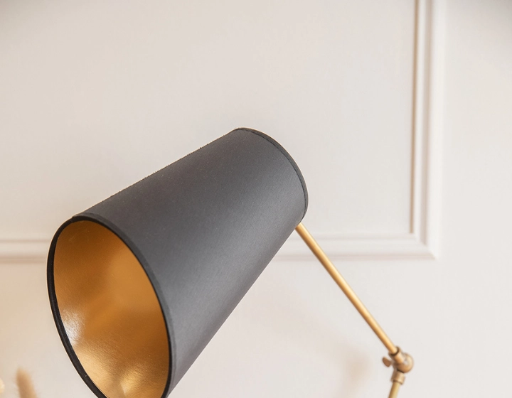 Black articulated desk lamp with black shade and gold interior Black articulated desk lamp with black shade and gold interior