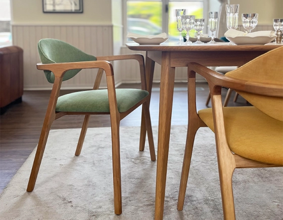 Designer chair with armrests natural wood stain and green fabric