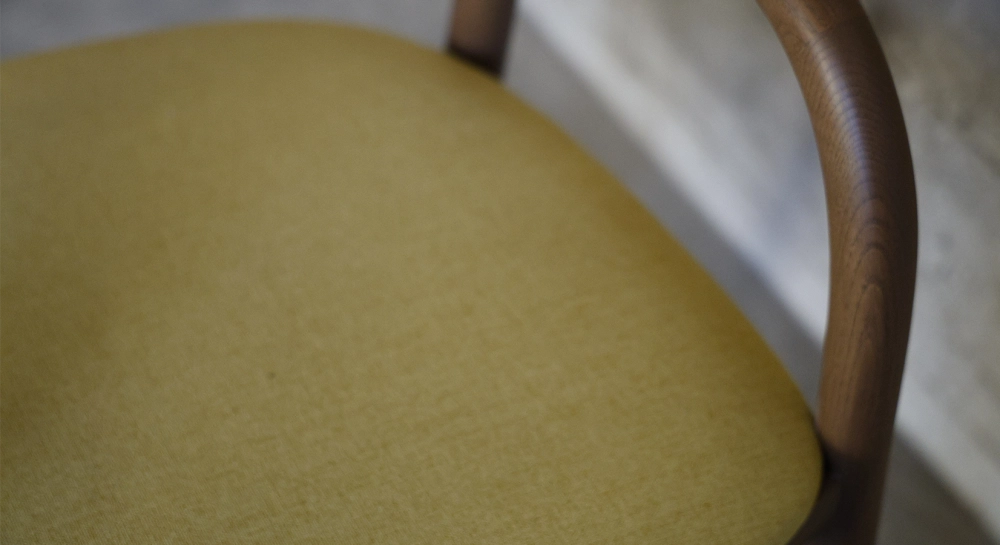 Chaise scandinave bois teinte noyer assise tissu jaune pâle